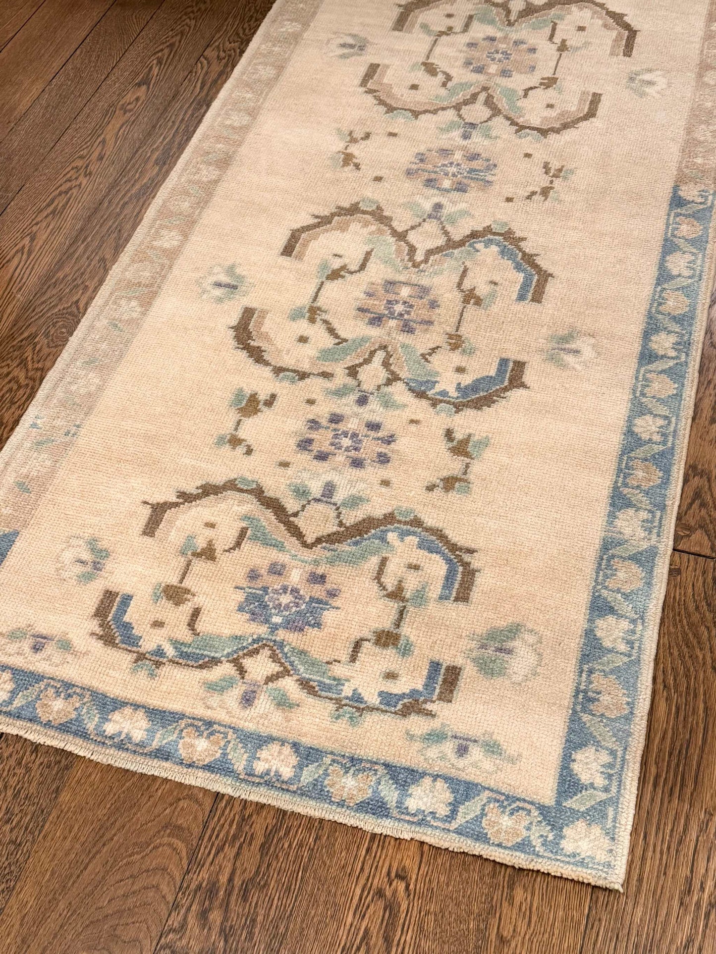 3’2”x6’7” Oushak runner with light beige background, brown, blue, green, and purple accents