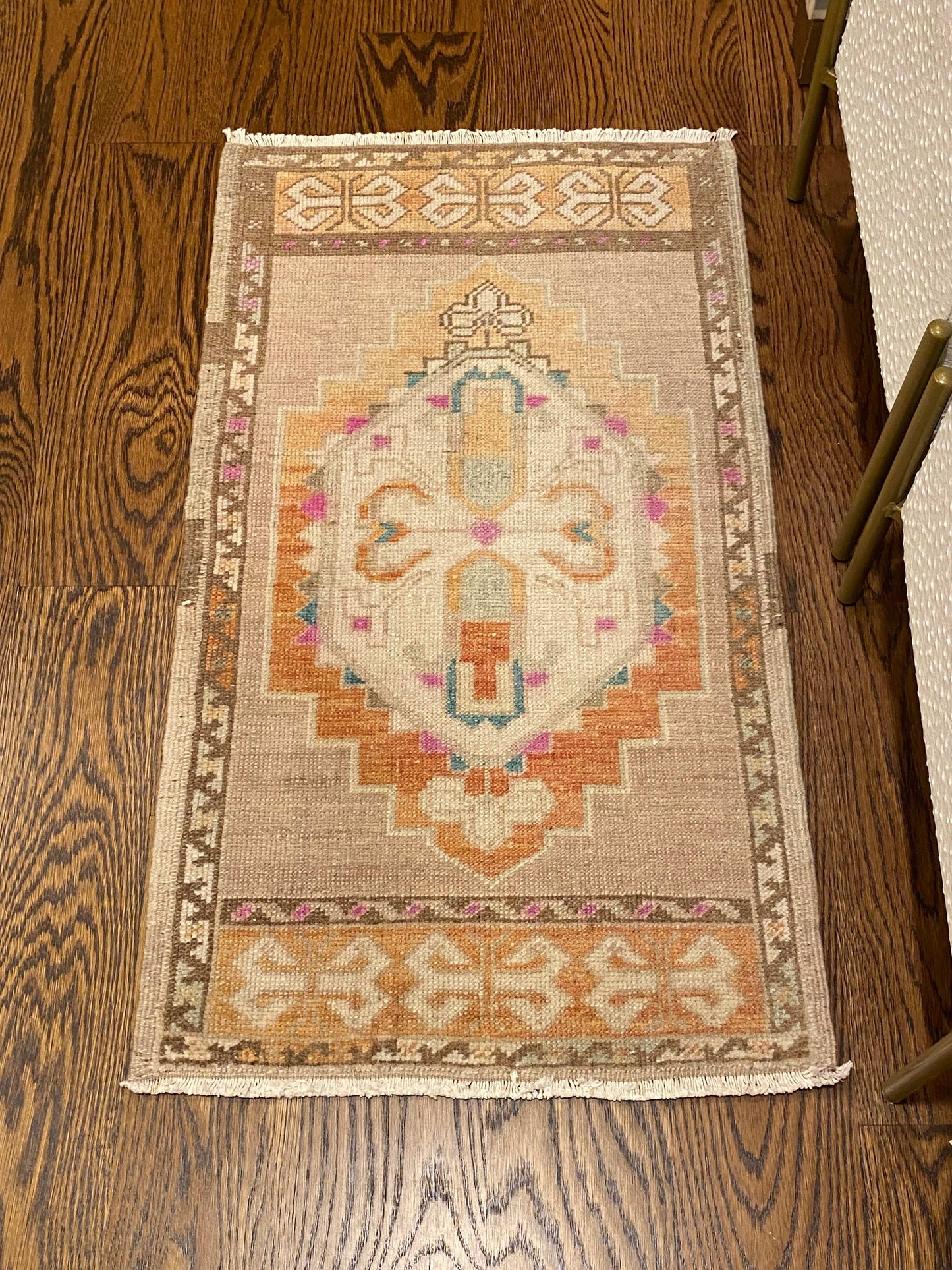 Vintage 1’8”x2’11” Oushak mat in beige, brown, orange, pink, and blue.