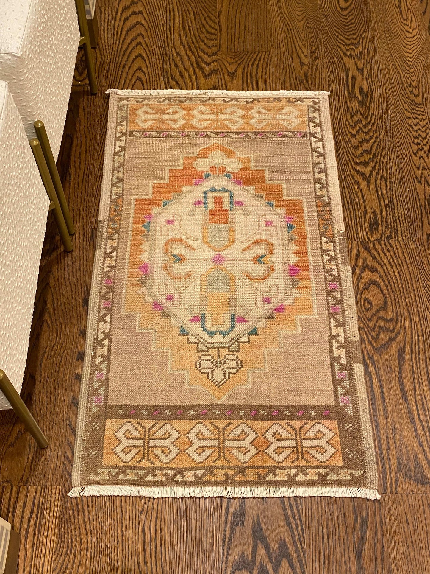 1’8”x2’11” vintage Oushak mat with light beige, brown, orange, pink, and blue design.