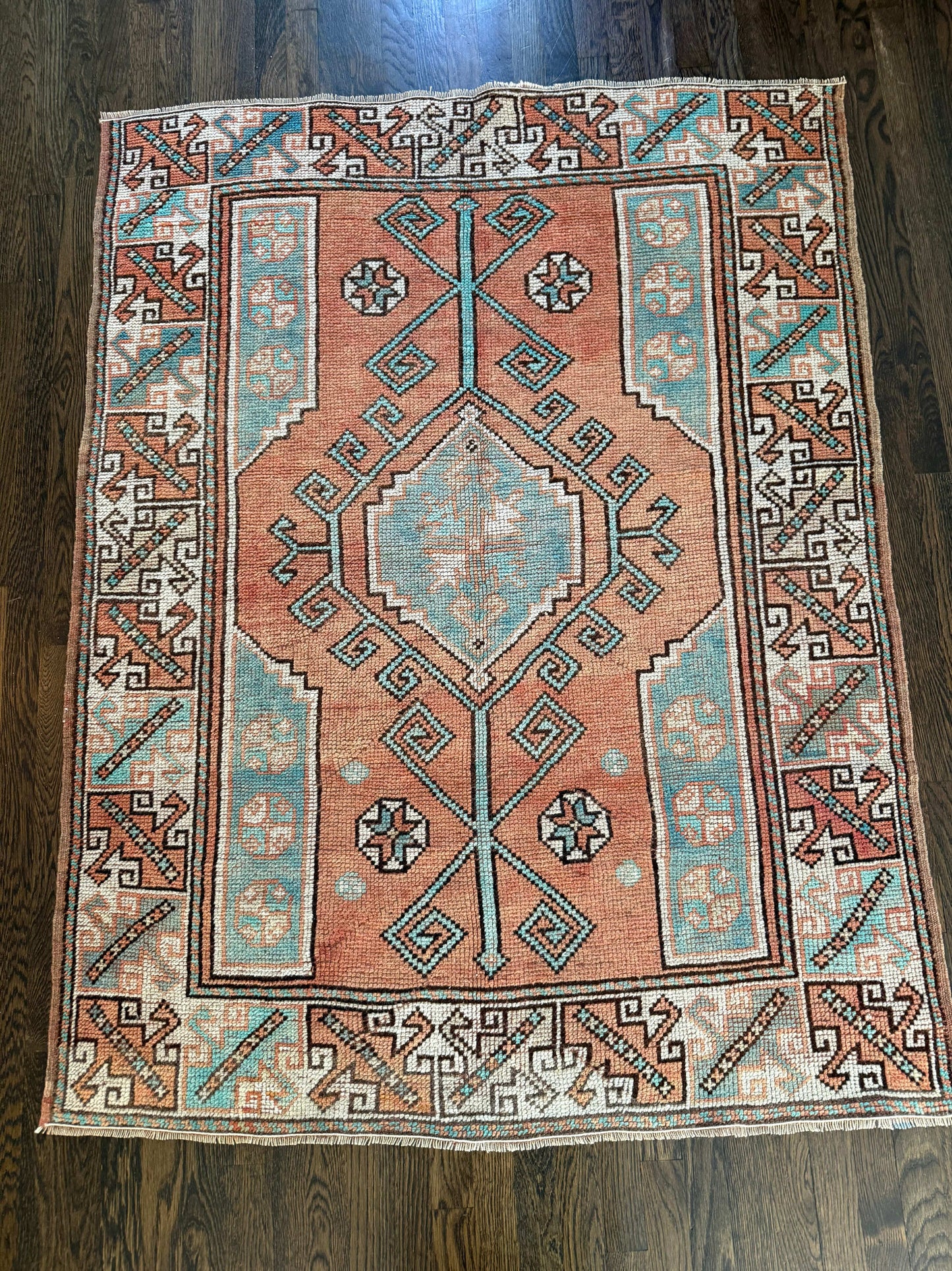 4’2” x 5’6” vintage hand-knotted rug with rust, turquoise, brown, and ivory colors.