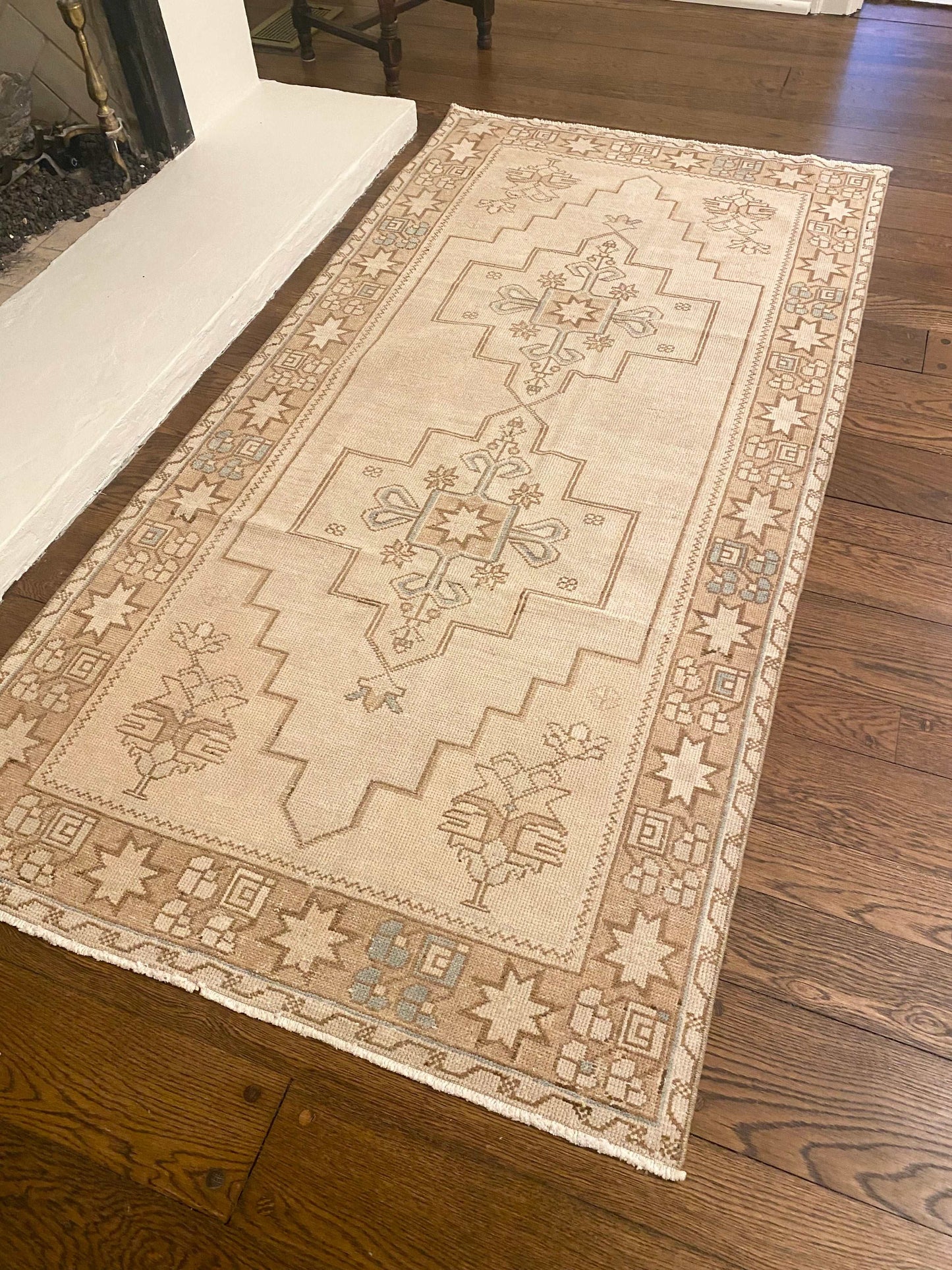 3’9”x7’9” vintage Oushak area rug with light beige background and brown, cream, and blue patterns.