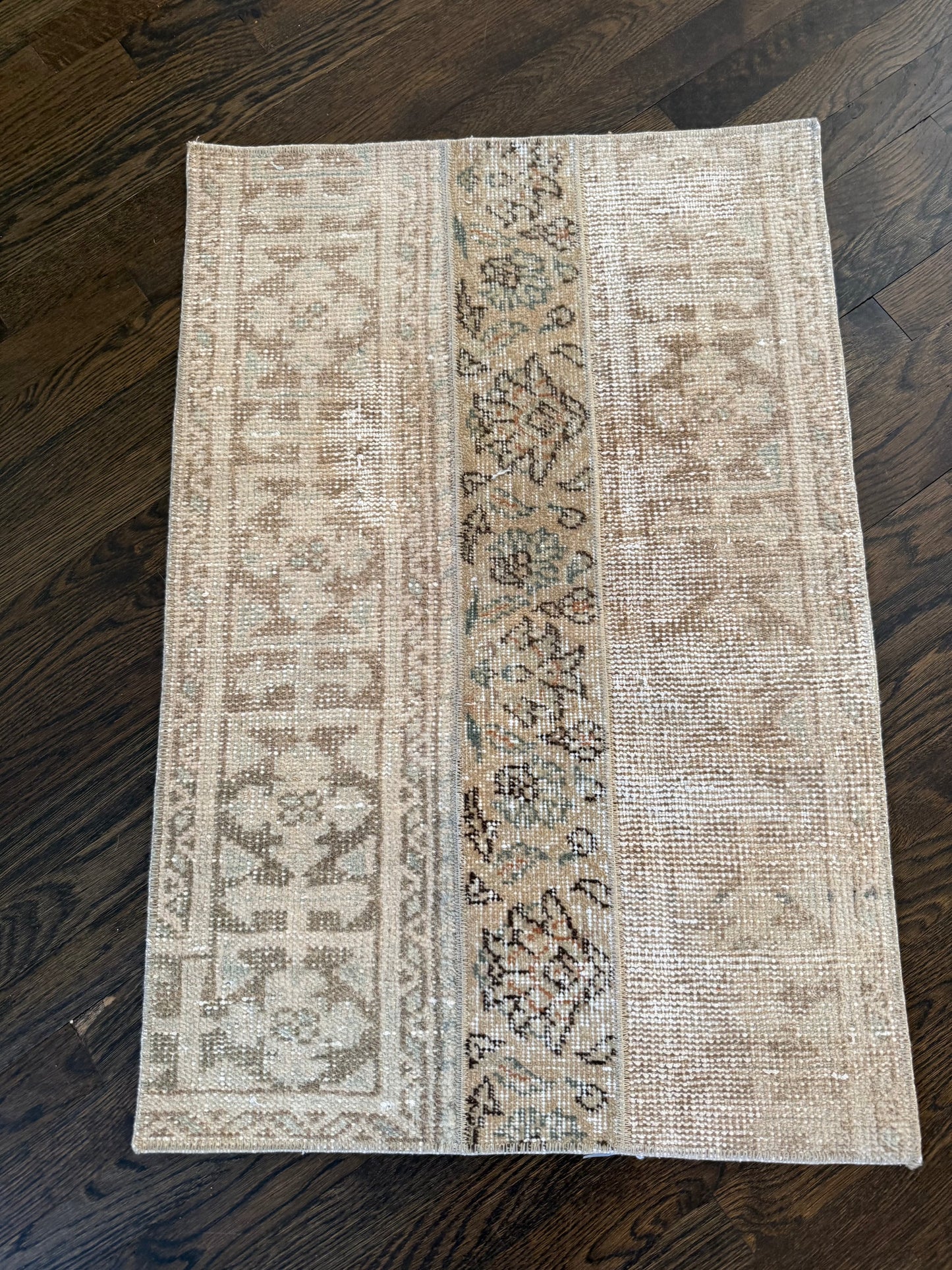 2’ x 3’ decorative mat with intricate pattern on dark wooden floor.