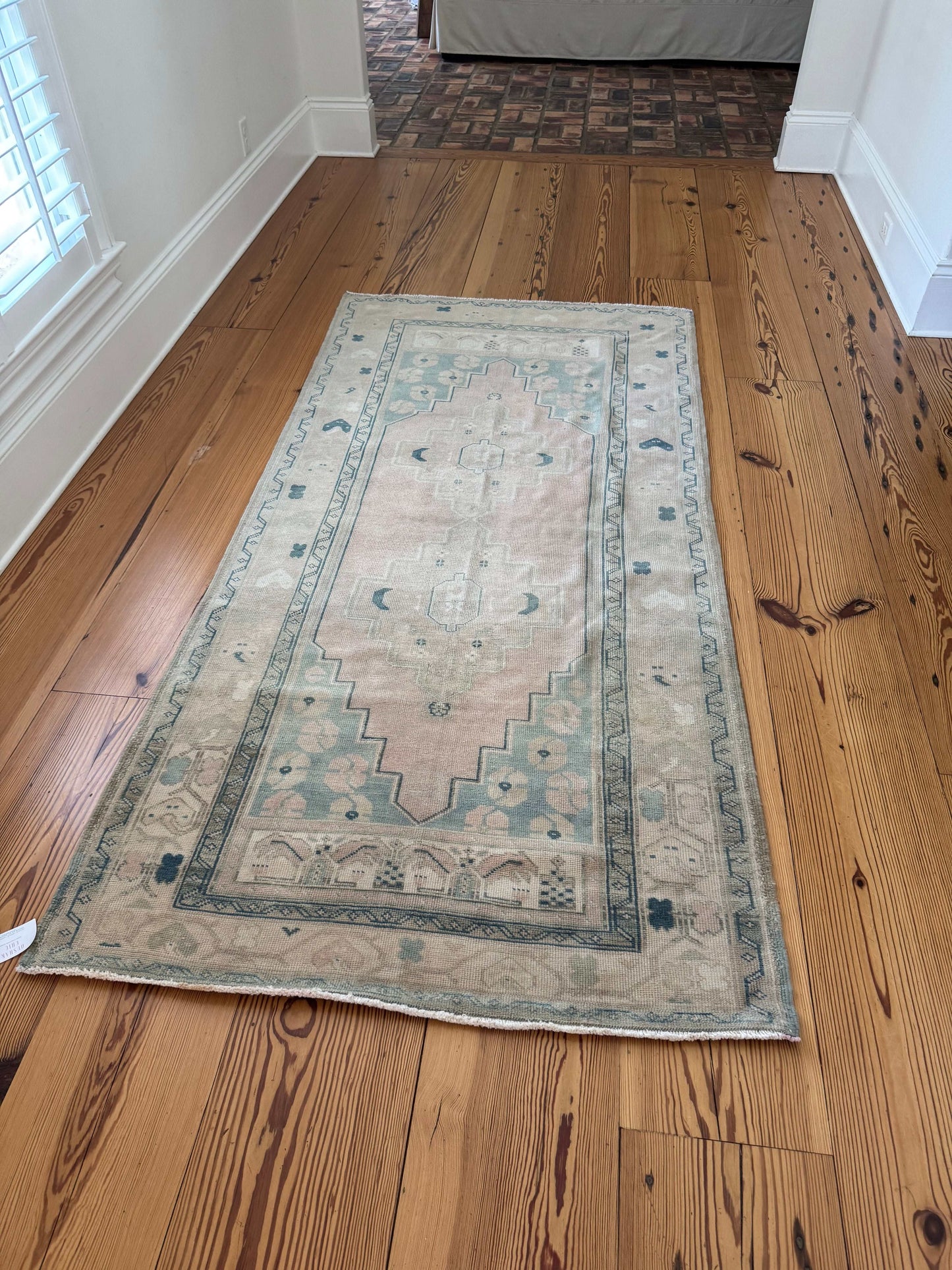 3’11”x8’0” vintage Oushak area rug in beige, cream, pink, and blue on wooden floor