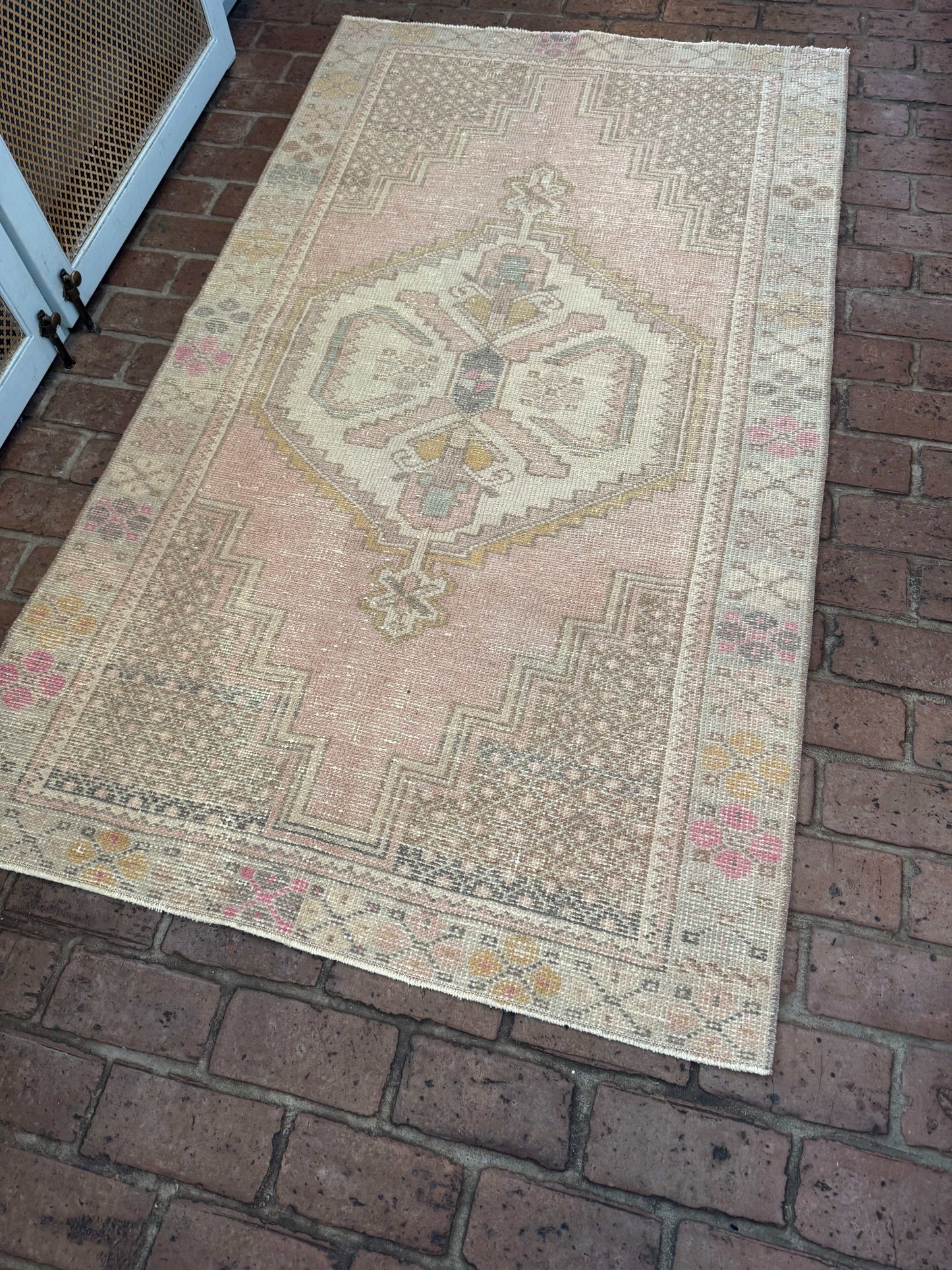 Decorative rug with intricate patterns on a brick surface