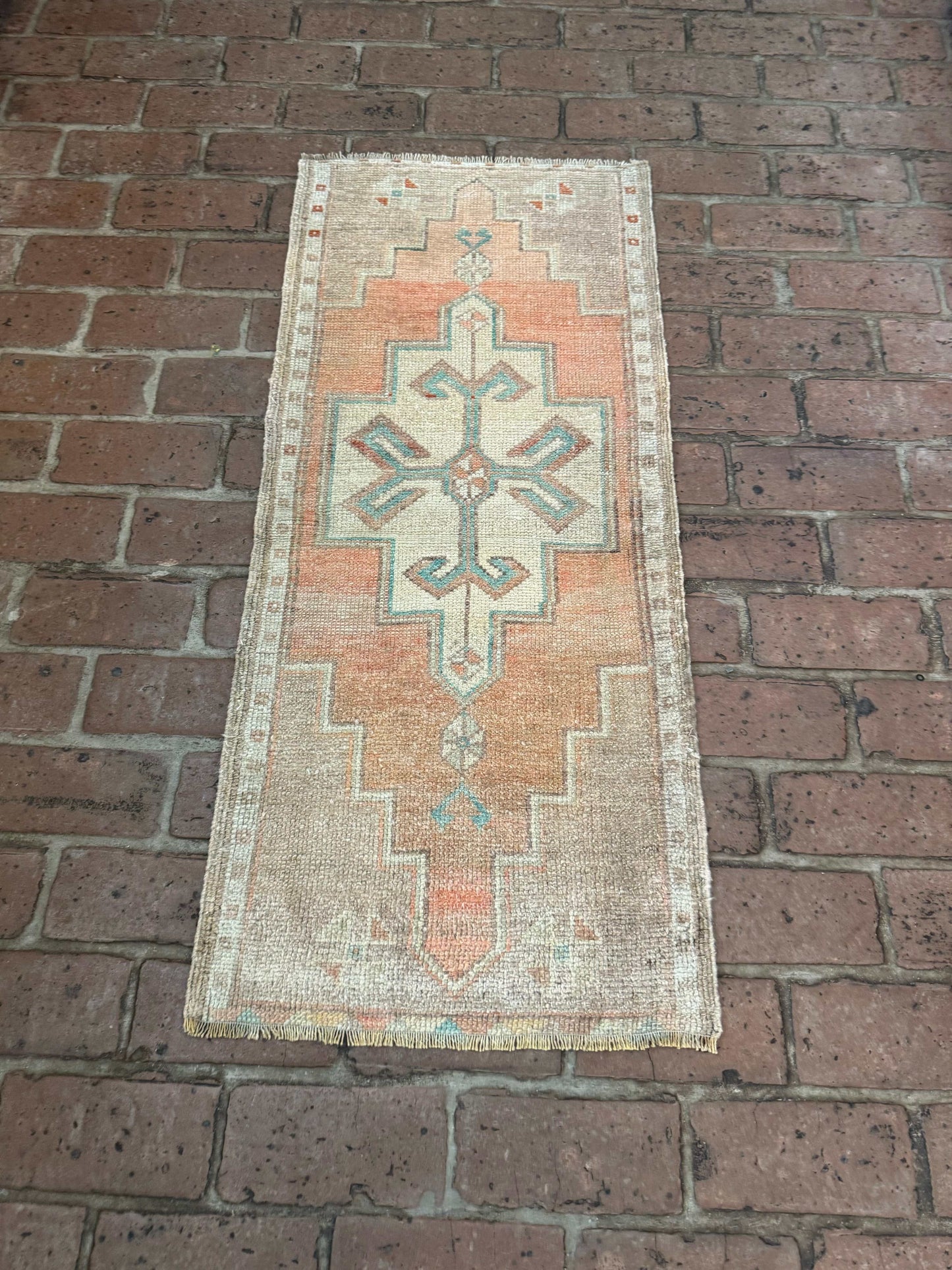 Small Turkish Oushak rug with orange, green, and brown patterns.
