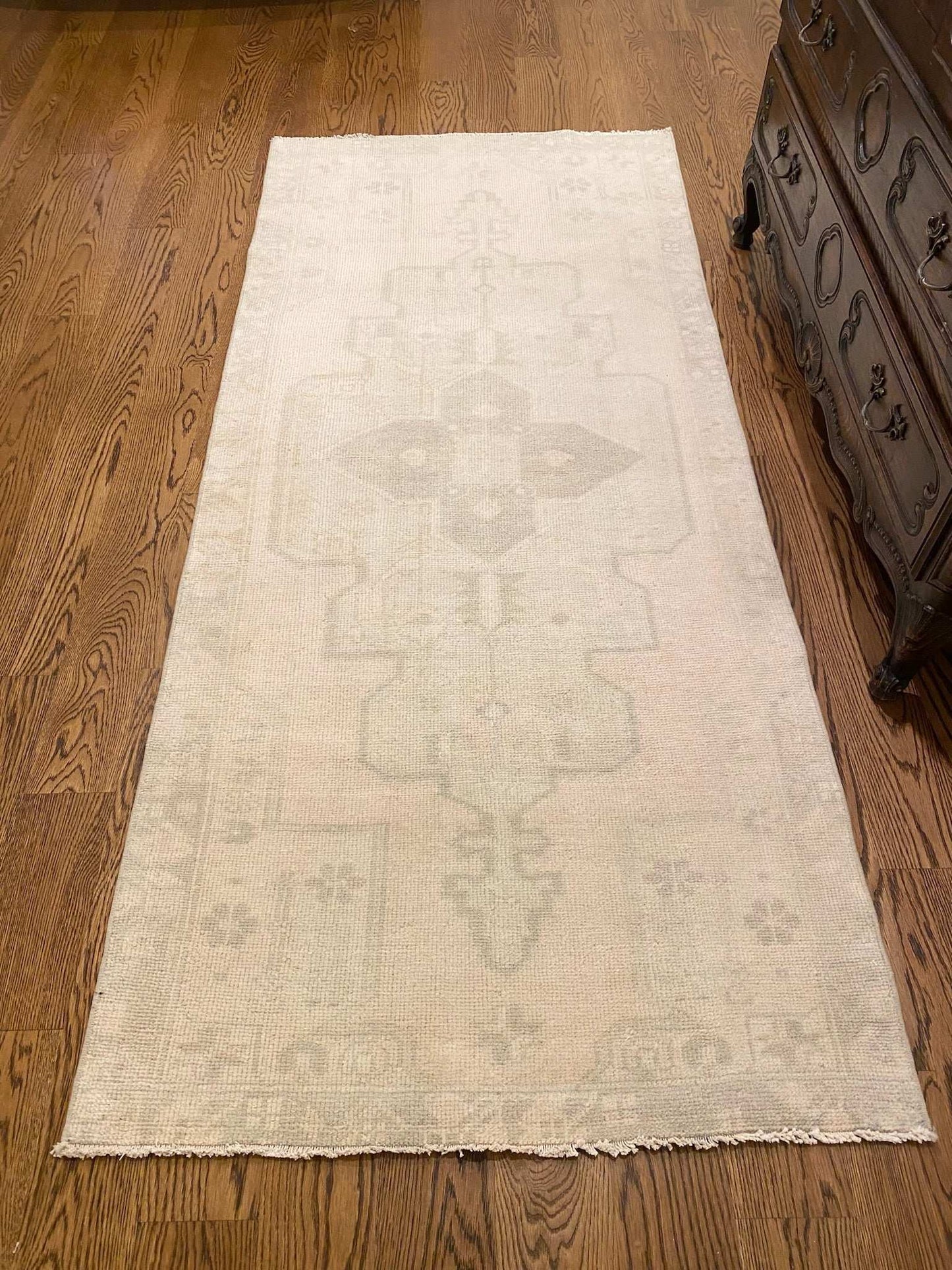 3'2" x 7'3" neutral area rug with center medallion design on wooden floor.