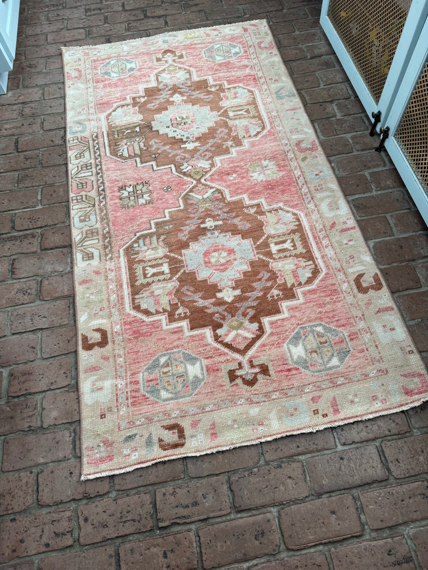 3'4" x 6'4" area rug with a true red background, brown medallions, and blue, gray, and green details.