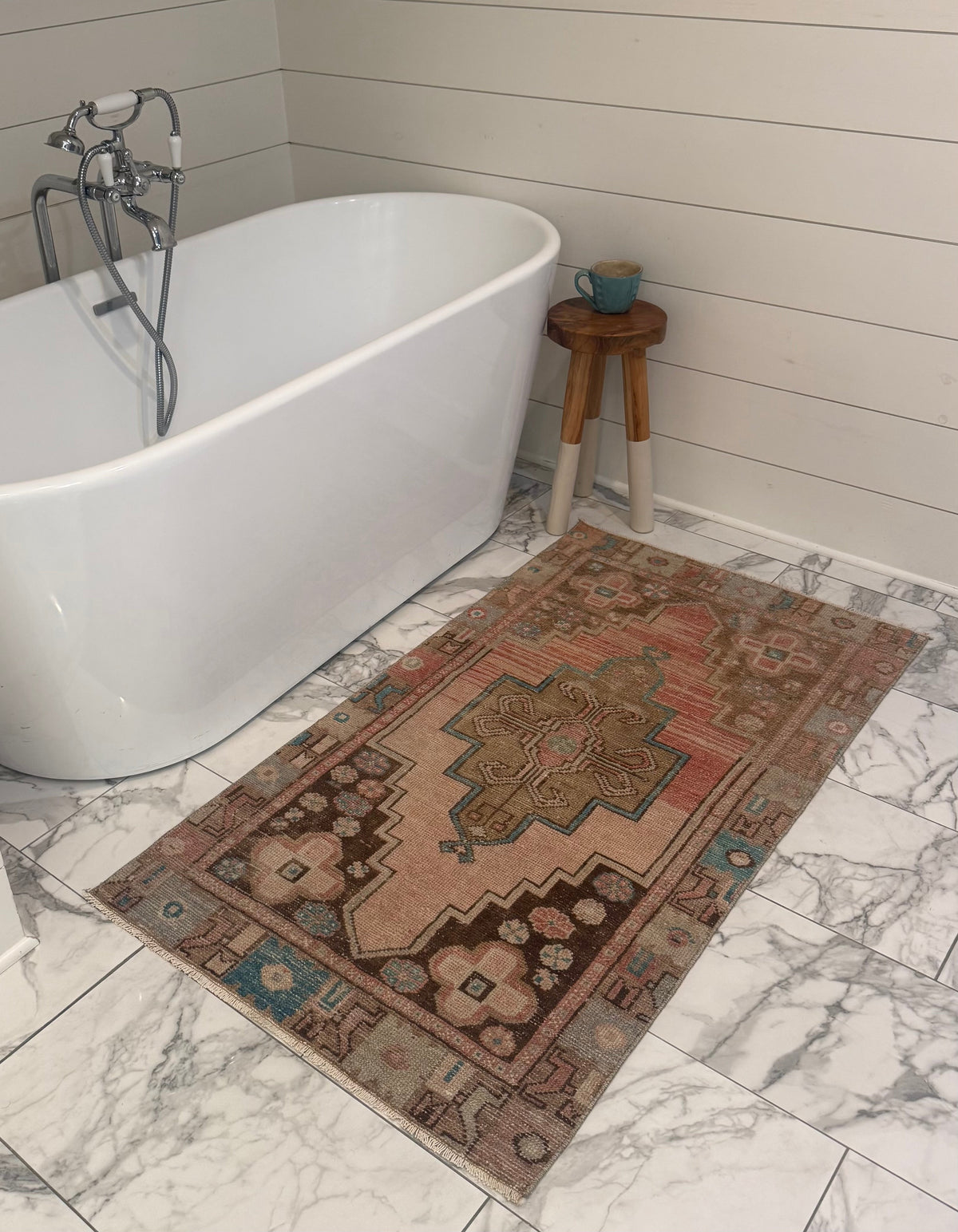 Vintage Rug with faded terracotta and blush tones, geometric medallion, floral motifs, and turquoise accents
