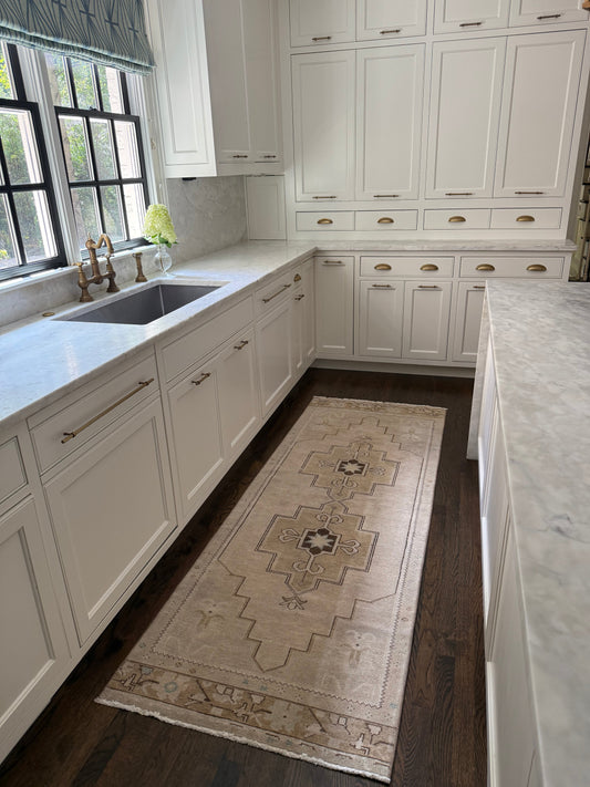 2’10” x 7’9” runner with brown and light blue accents in a white kitchen on dark wood floor