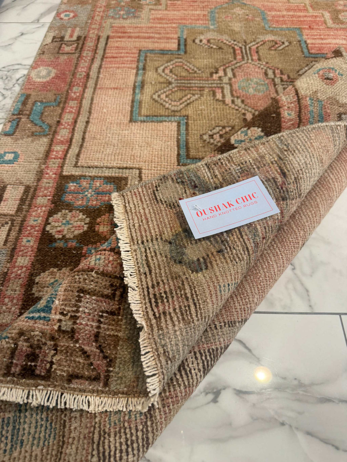 Vintage Rug with faded terracotta and olive-brown floral medallion, turquoise accents, wool weave and fringed edges