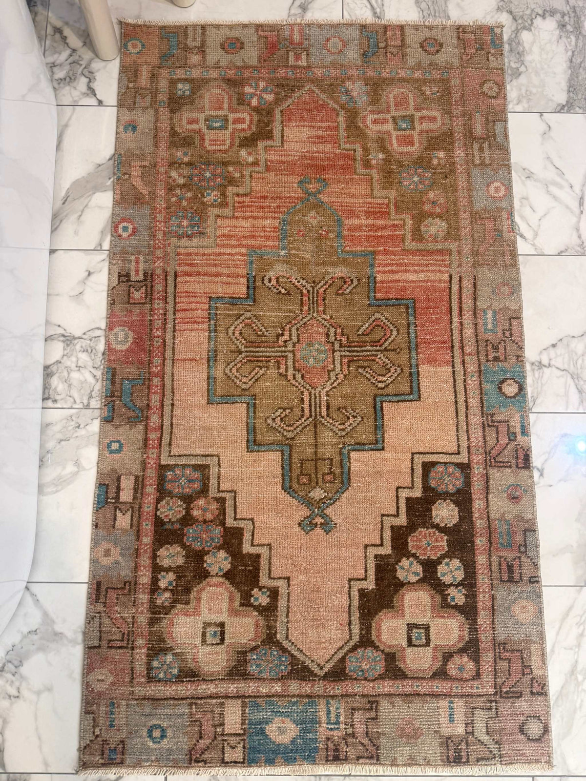 Vintage Rug with hand-knotted wool, faded terracotta field, olive medallion, and turquoise floral border details