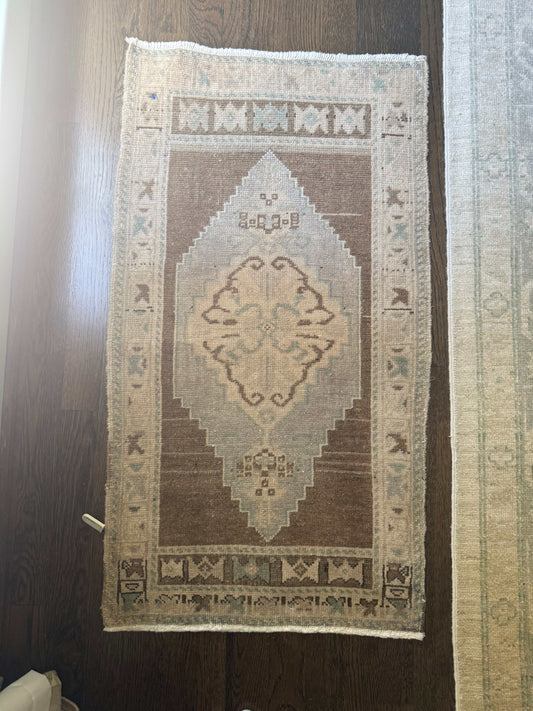 1’9” x 3’1” mini rug with geometric pattern on dark wood floor