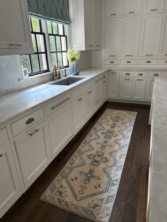 2’4” x 9’0” runner rug with classic design in a modern white kitchen on dark hardwood floor