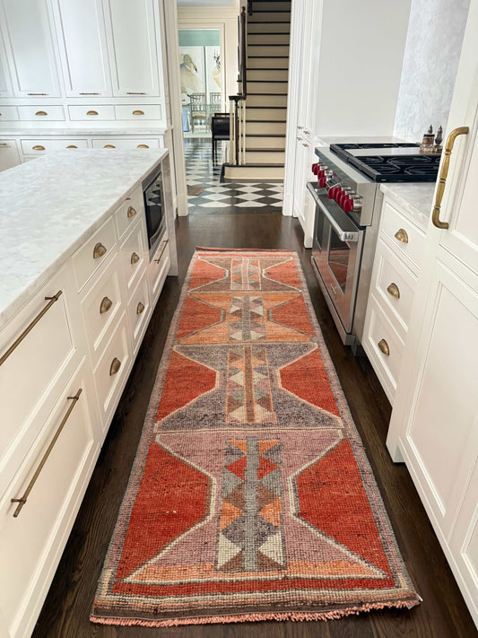 3' x 10'1" rug runner with bold orange and gray geometric pattern on hardwood floor in modern kitchen
