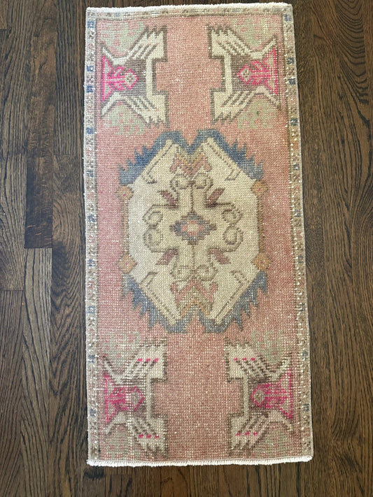 1'6" x 3'3" Turkish rug mat with hand-knotted craftsmanship in mauve pink, gray-blue, brown, and hot pink accents on wooden floor