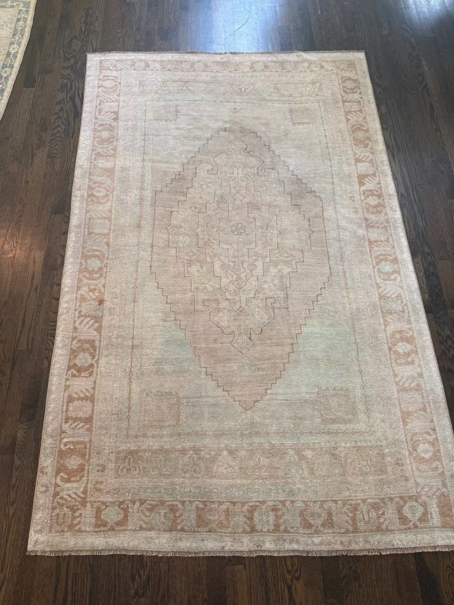 4’7” x 7’3” vintage area rug with light blue, beige, grey, brown, soft green, and muted yellow colors