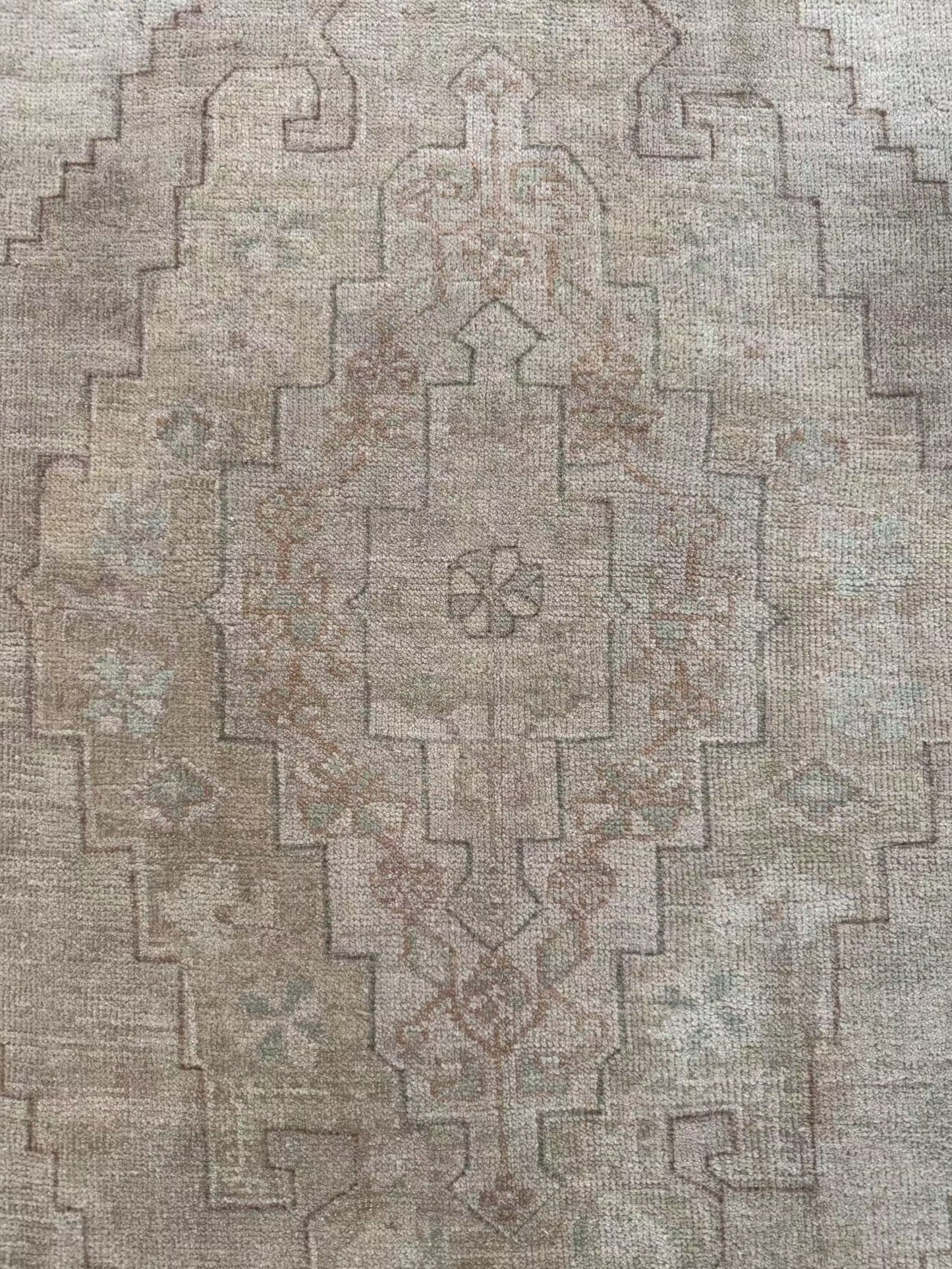 4’7” x 7’3” vintage area rug with light blues, beige, grey, brown, soft greens, and muted yellows