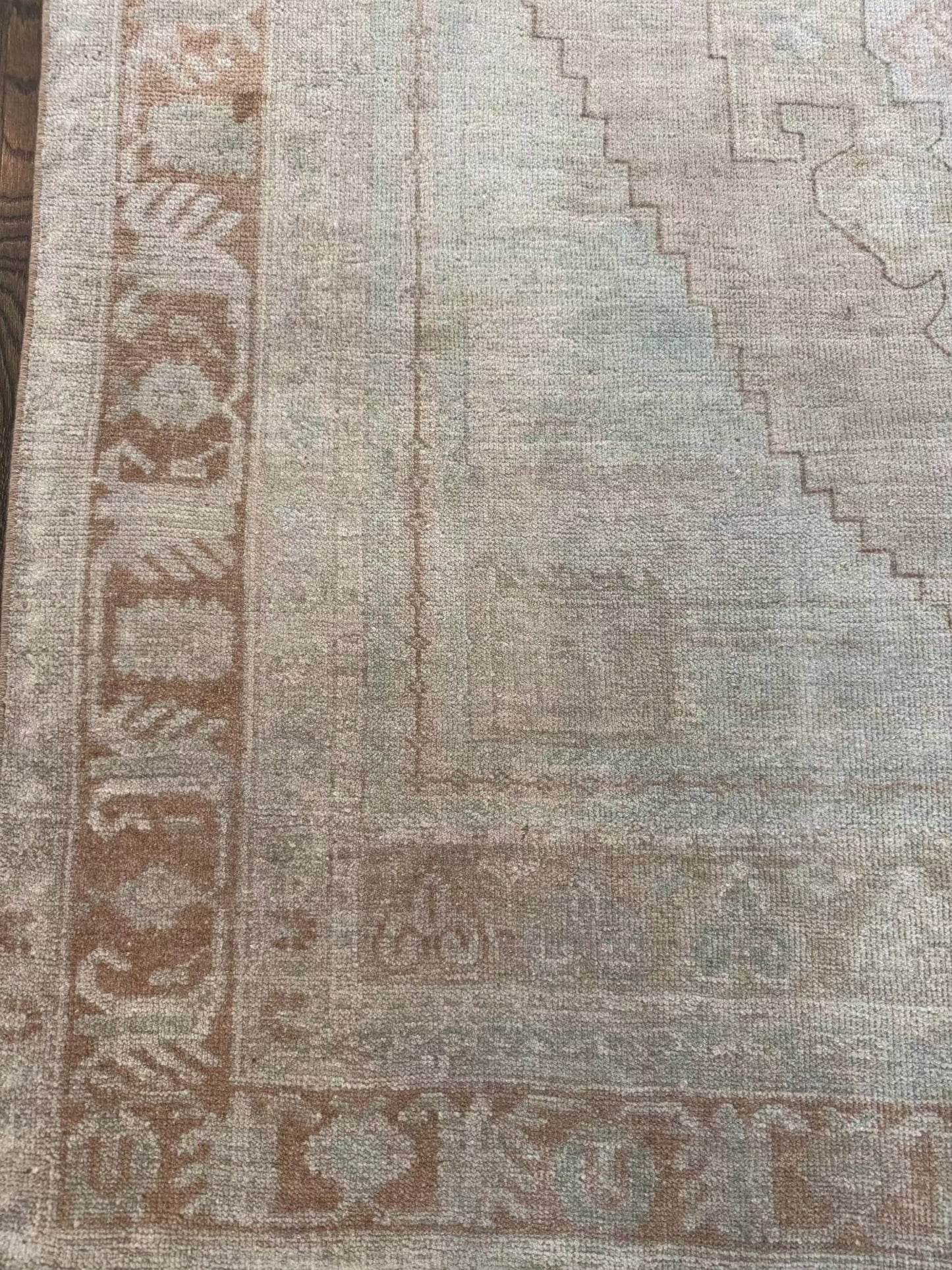 4’7” x 7’3” vintage area rug with light blues, beige, grey, brown, soft greens, and muted yellows