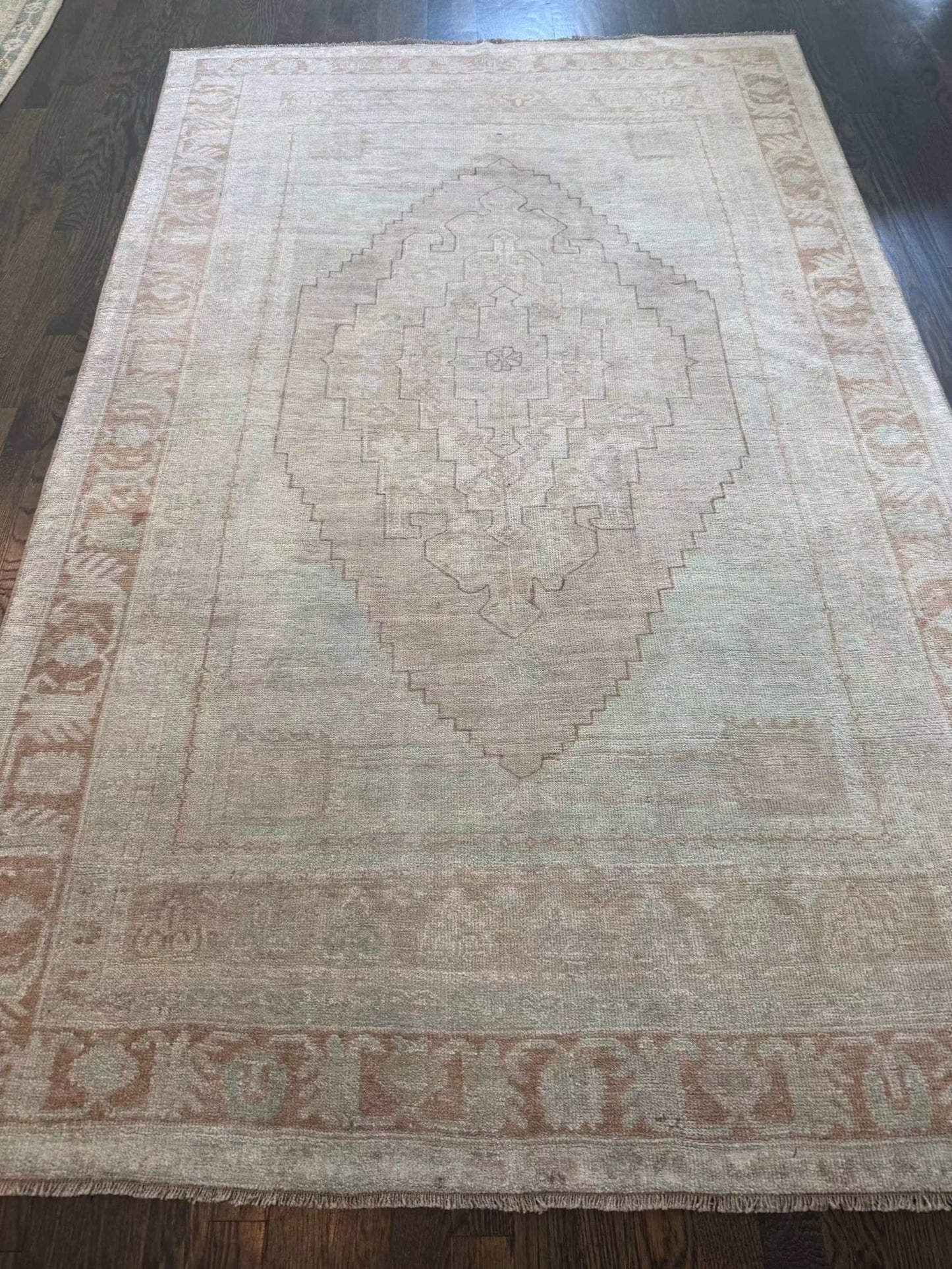 4’7” x 7’3” vintage area rug with subtle blues, beige, grey, brown, green, and yellow tones