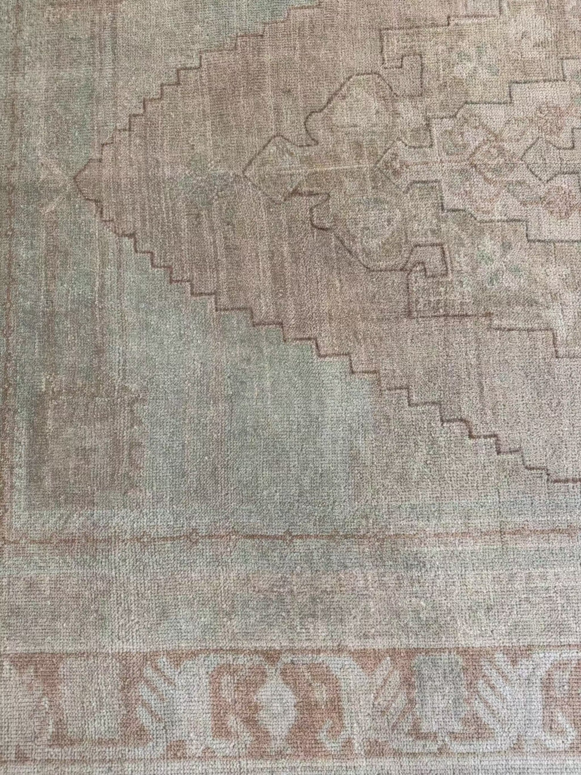 4’7” x 7’3” vintage area rug with subtle light blues, beige, grey, brown, soft greens, and muted yellows