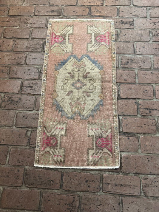 1'6" x 3'3" Turkish Rug with mauve pink, gray-blue, brown, and hot pink accents on brick floor