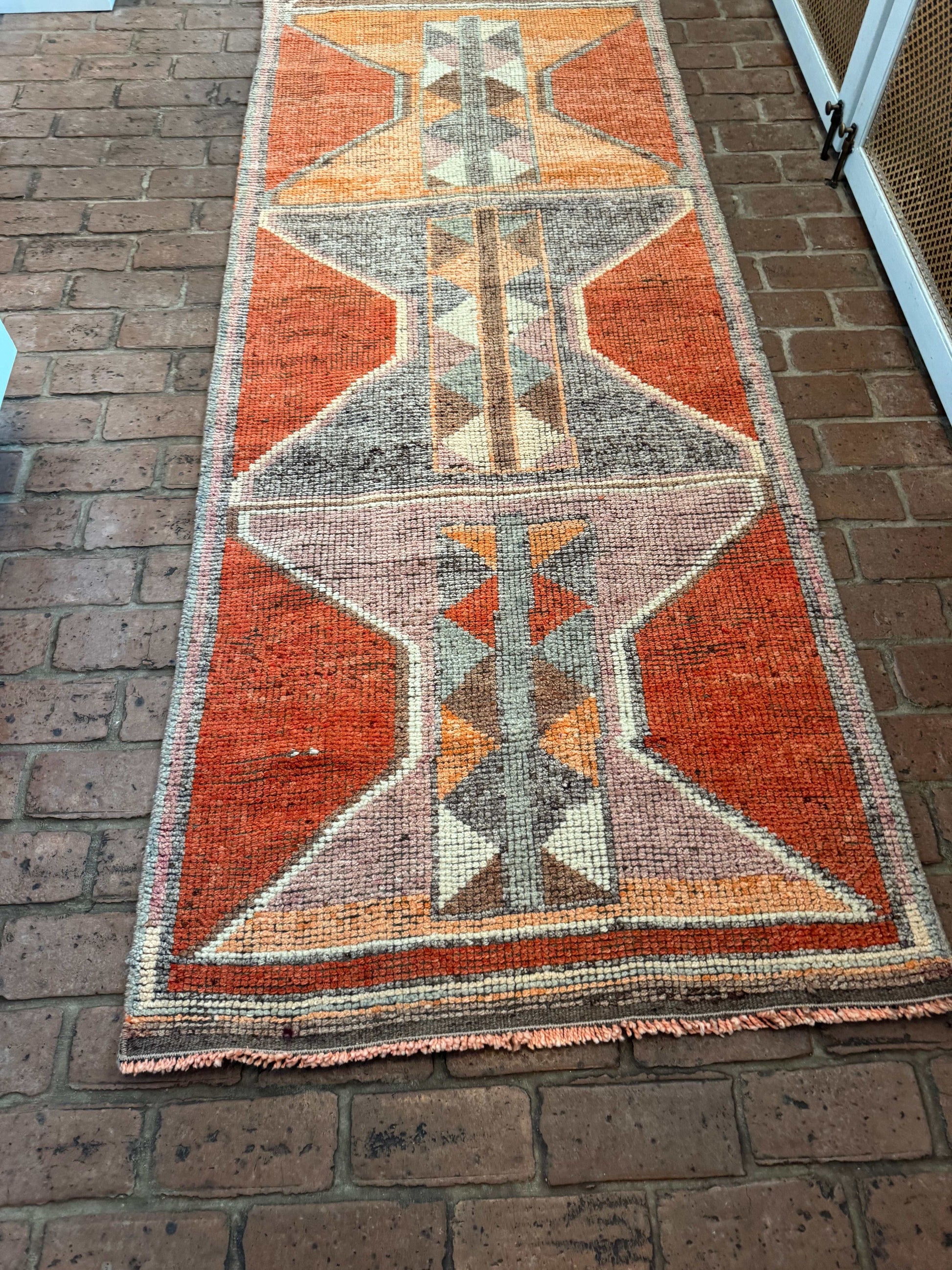 Geometric patterned rug on a brick floor