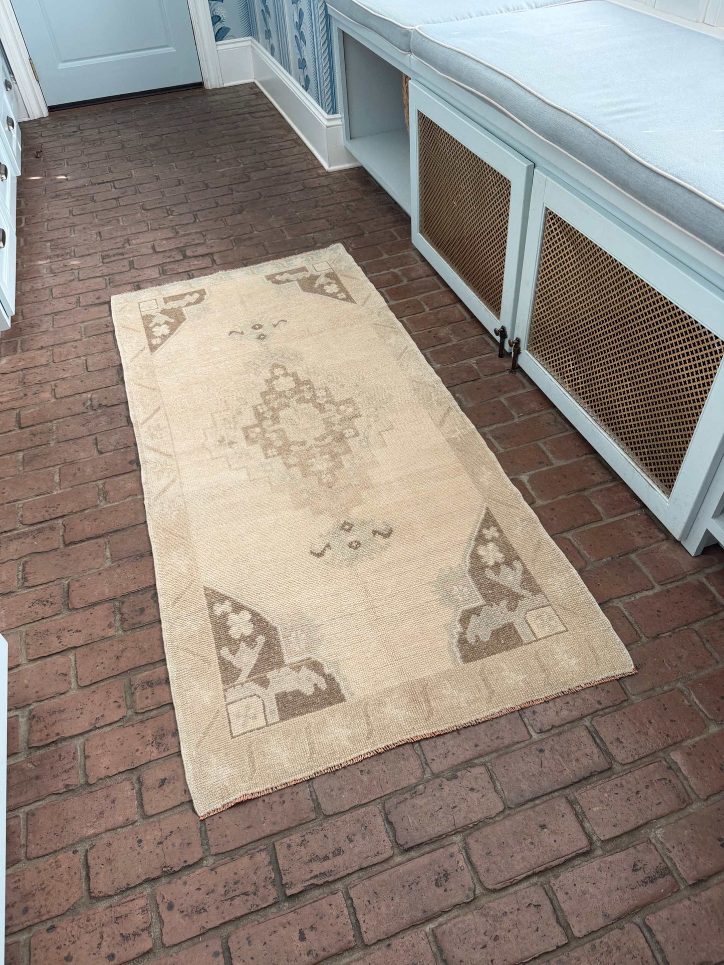 Hand knotted Turkish rug with taupe, brown, and blue center medallion design measuring 2'11" x 6'5"