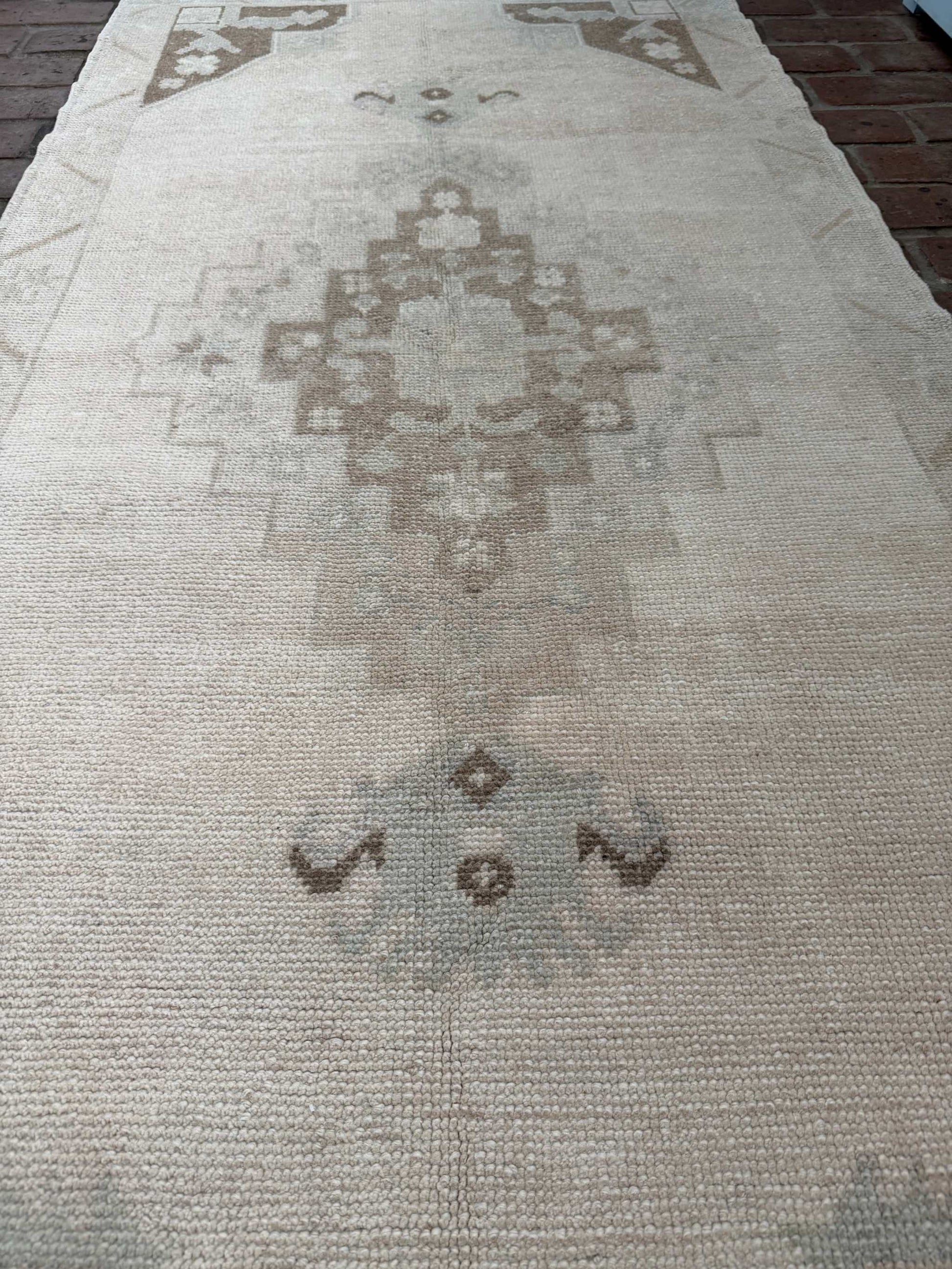 Hand knotted Turkish rug in taupe, brown, and blue with classic center medallion design measuring 2'11" x 6'5"