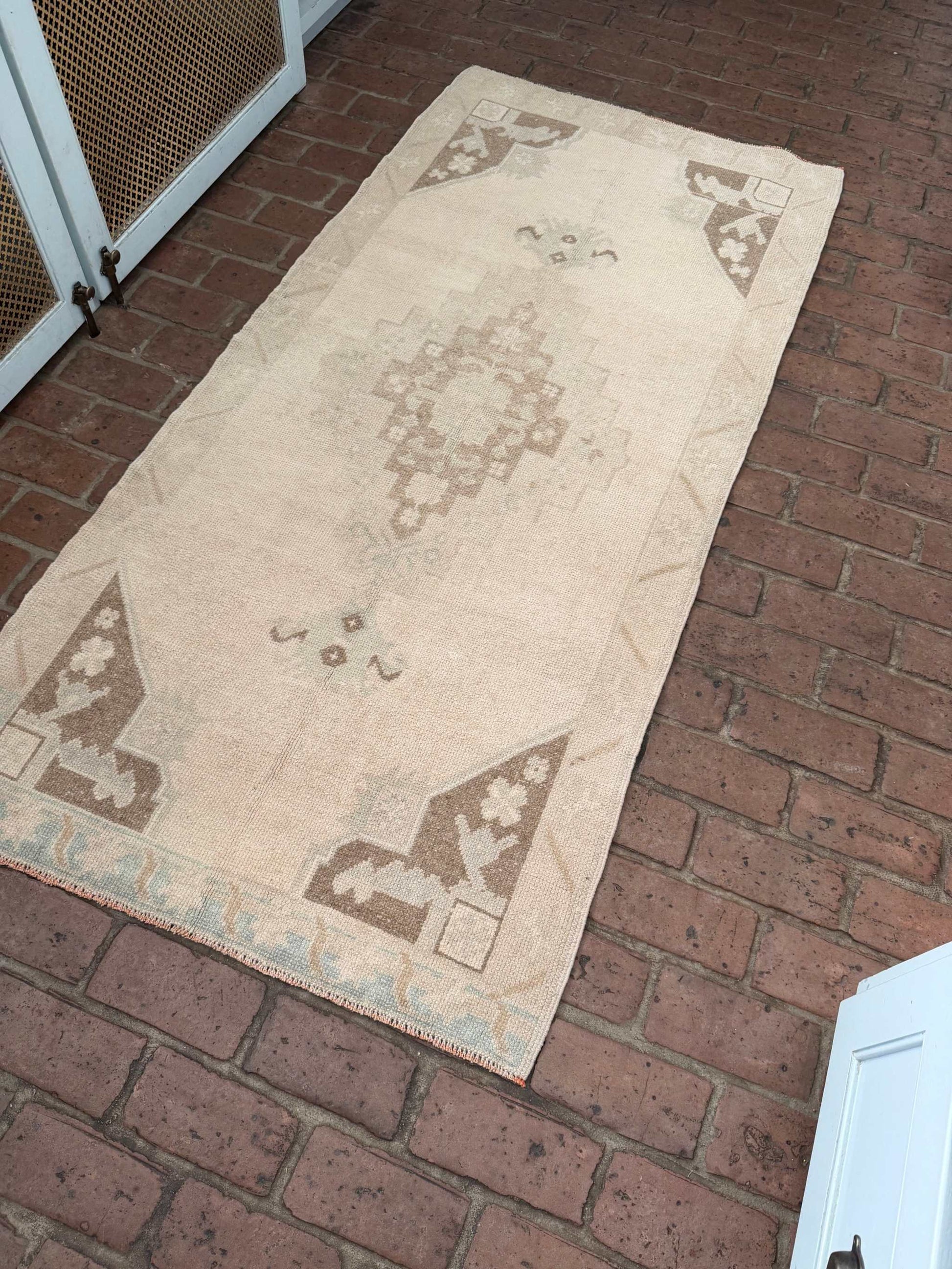 Hand knotted Turkish rug with taupe, brown, and blue center medallion design measuring 2'11" x 6'5"