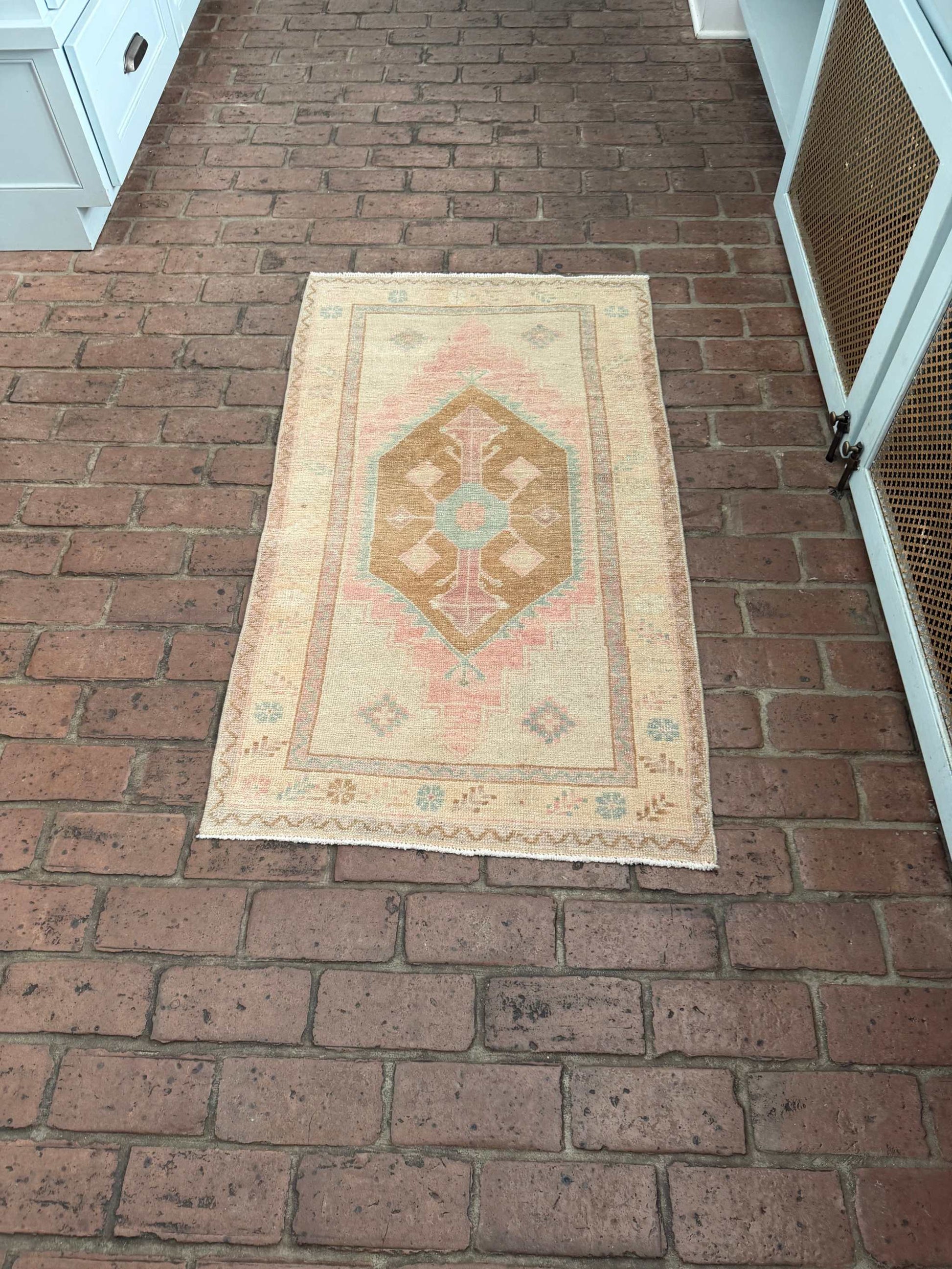 Small colorful area rug with pink, blue, and brown medallion design measuring 2'4" x 4'3"