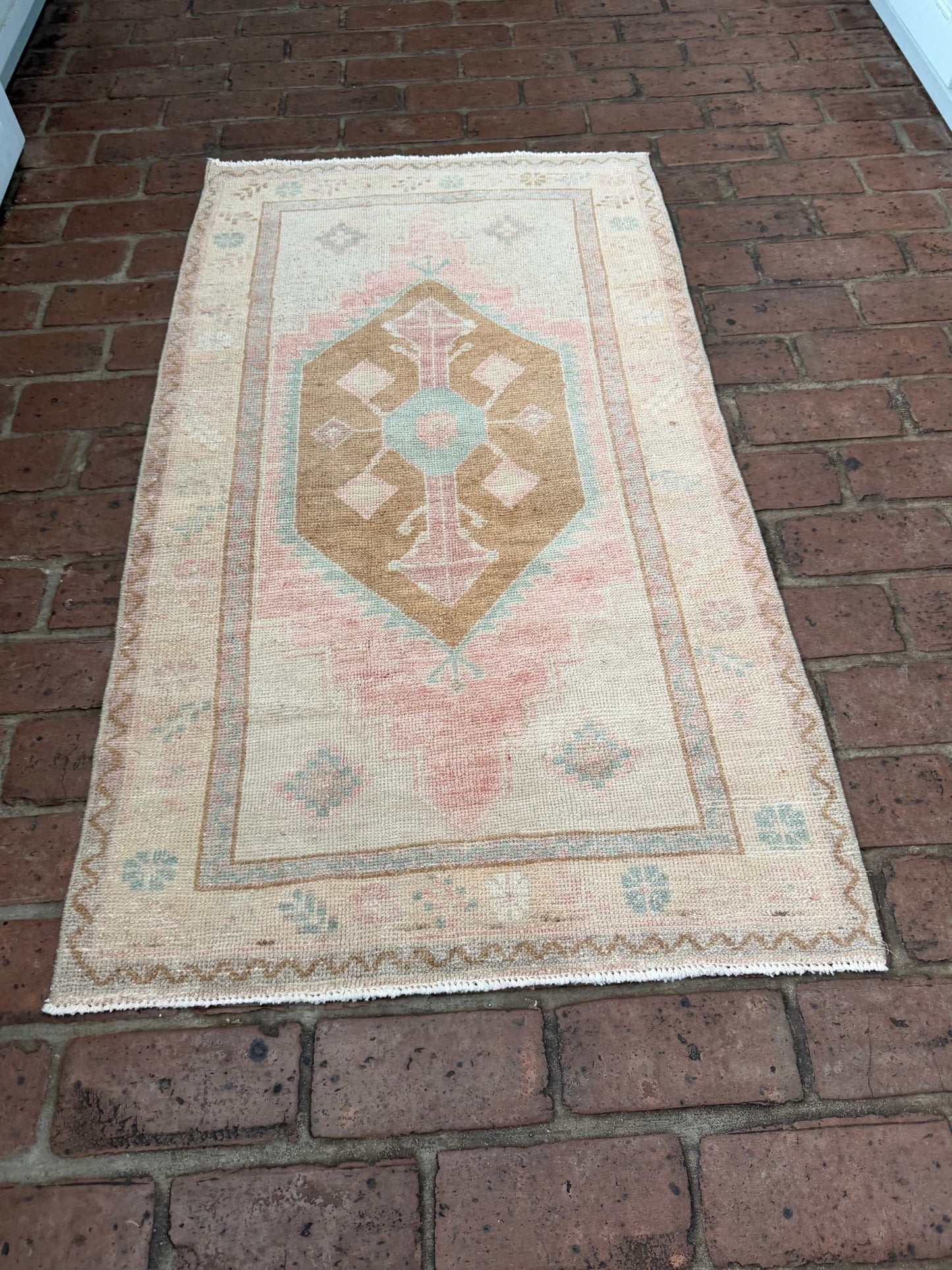 Small colorful area rug 2'4" x 4'3" with pink, blue, and brown center medallion design