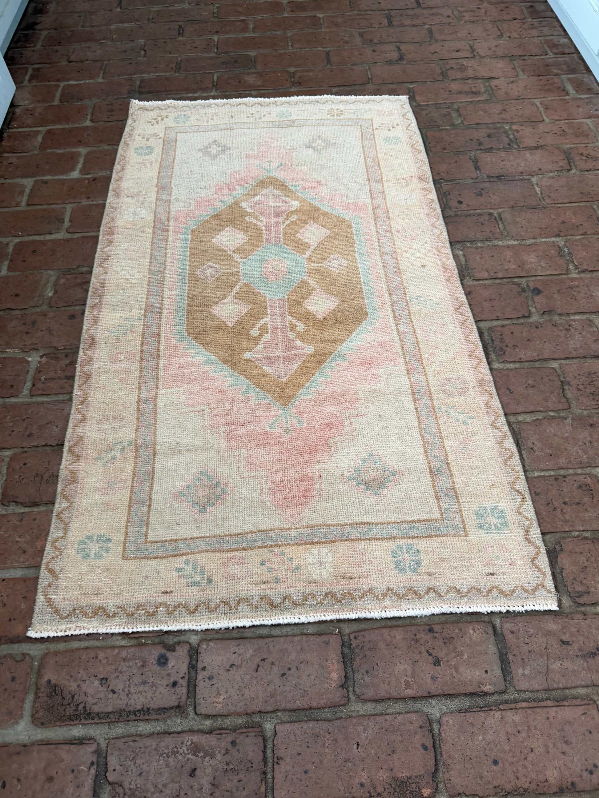 Small colorful area rug 2'4" x 4'3" with pink, blue, and brown center medallion design
