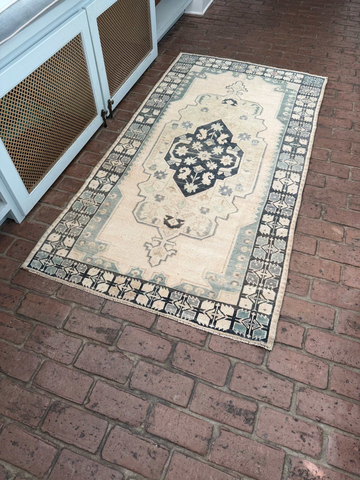 3'4" x 6'5" hand knotted area rug with blues, greens, taupe, and pink spot featuring classic center medallion design
