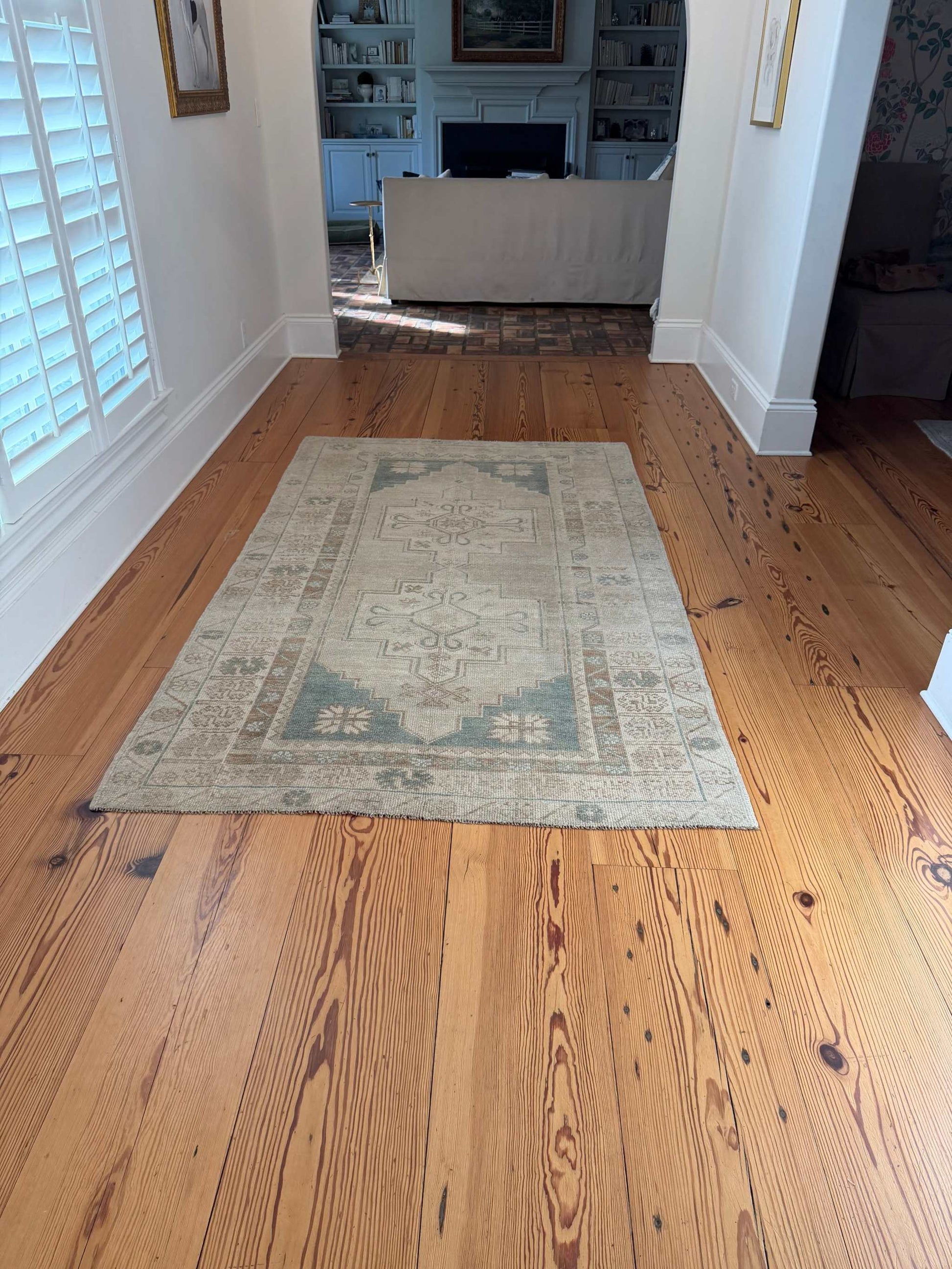 4'8" x 8'1" hand knotted area rug with neutral background and teal double center medallions