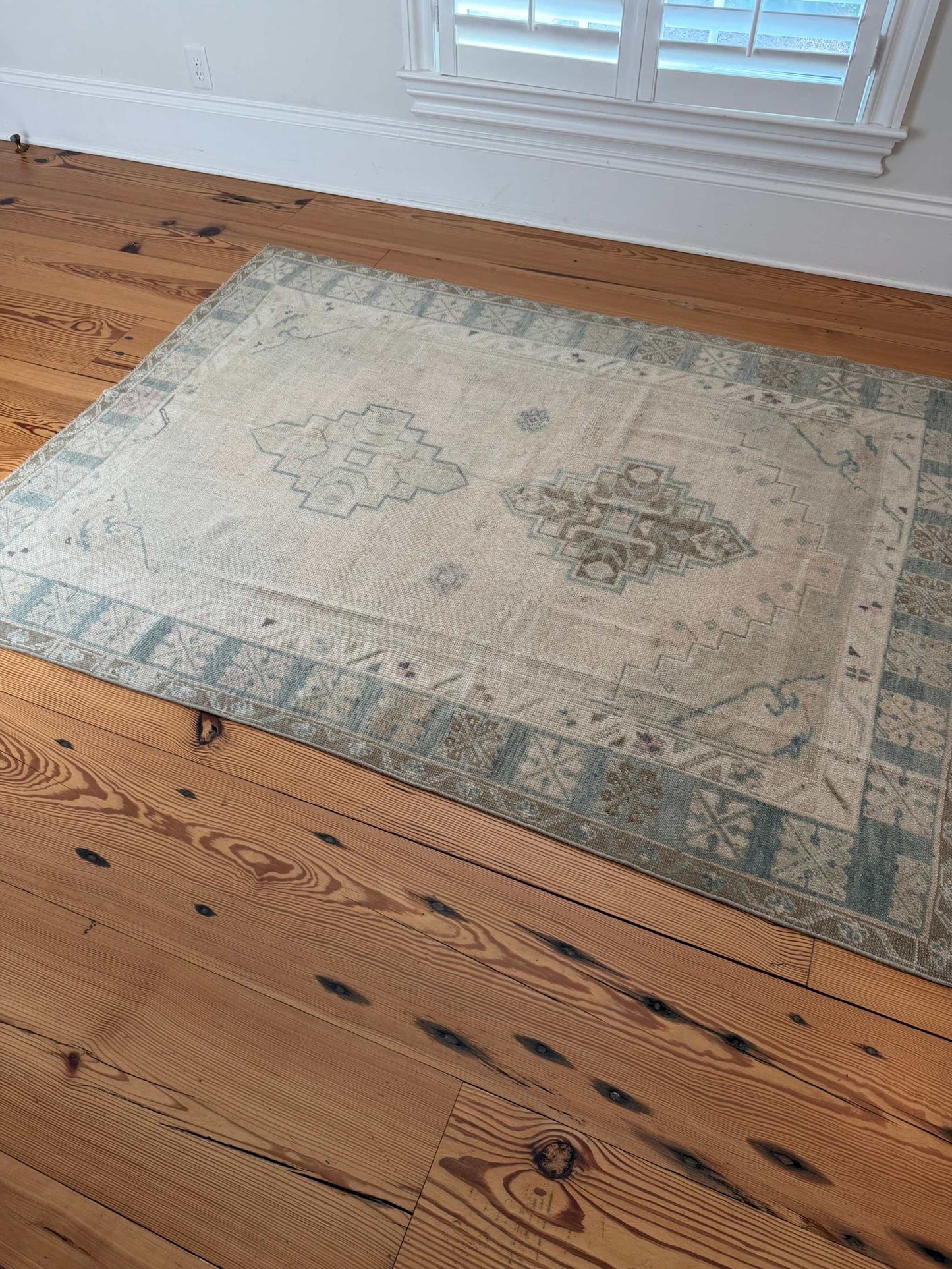 4'11" x 6'6" hand knotted square area rug with neutral background, soft blue-greens, and hot pink accents