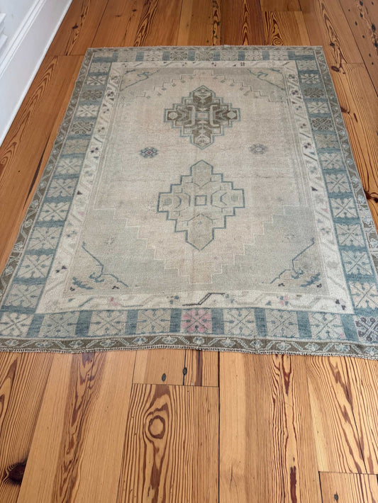 4'11" x 6'6" hand-knotted Turkish square area rug with neutral background and blue-green accents