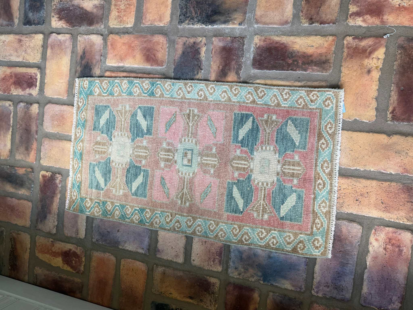 Small vintage hand-knotted Turkish Mat with blues, pink, and red-brown colors