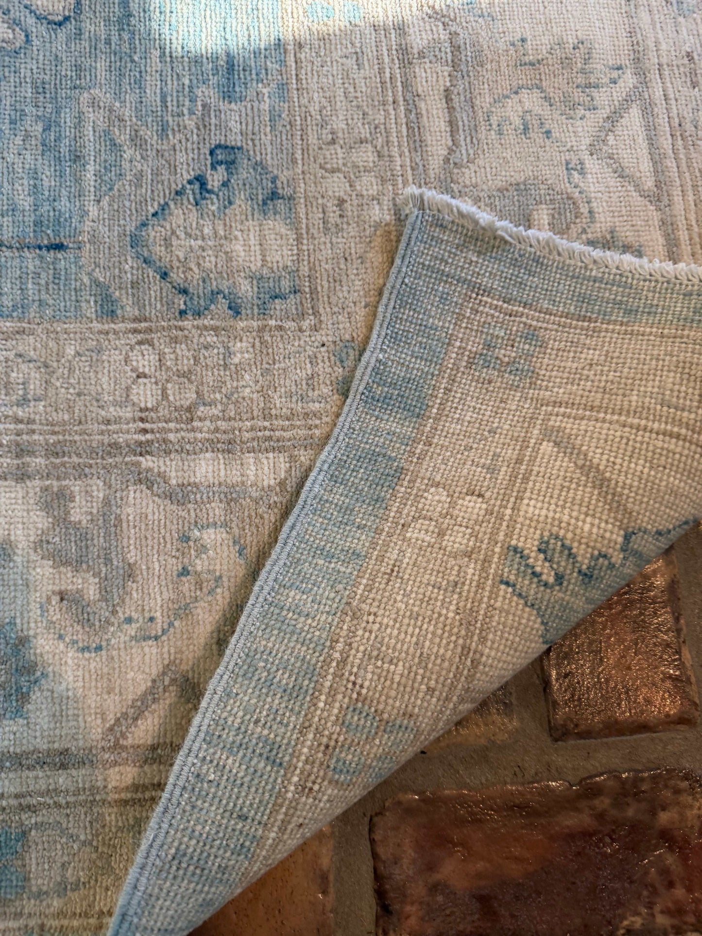 Close-up of a patterned rug with a textured border