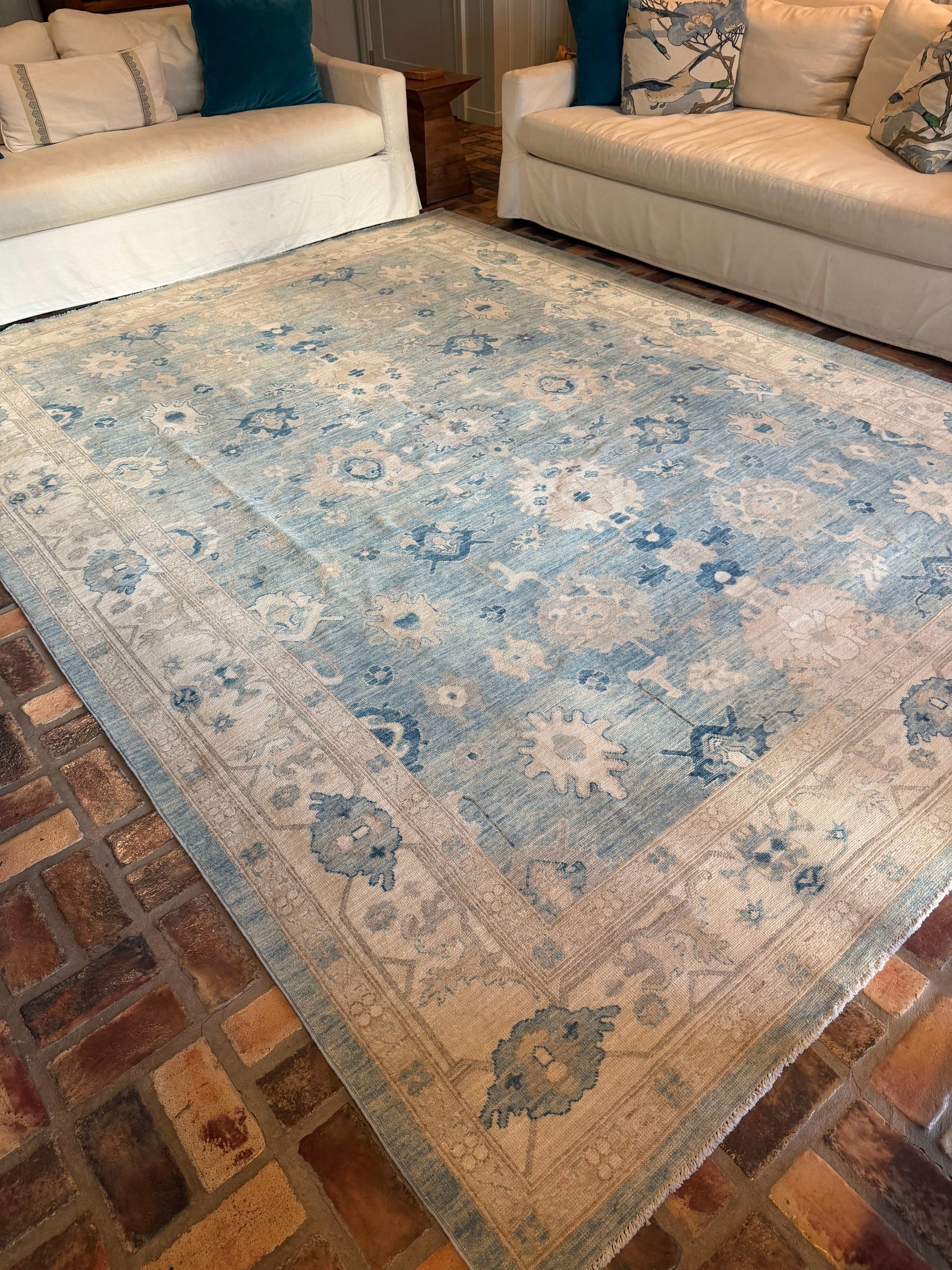 Decorative rug with floral patterns on a brick floor