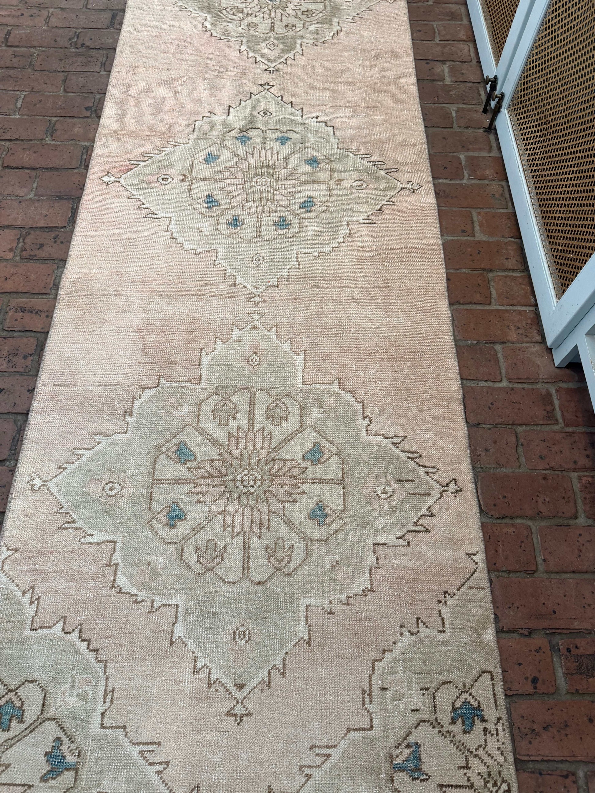 Decorative rug with geometric pattern on a brick floor
