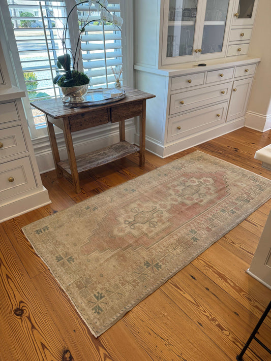 Soft red and beige 7' area rug with double center medallion design.