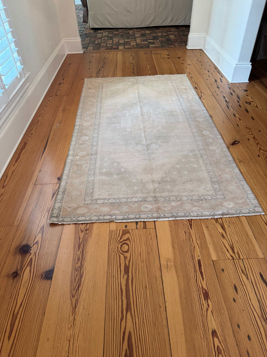 8'2" neutral area rug with ivory and beige tones, brown and gray border, and muted moss green accents, featuring a classic center medallion design.