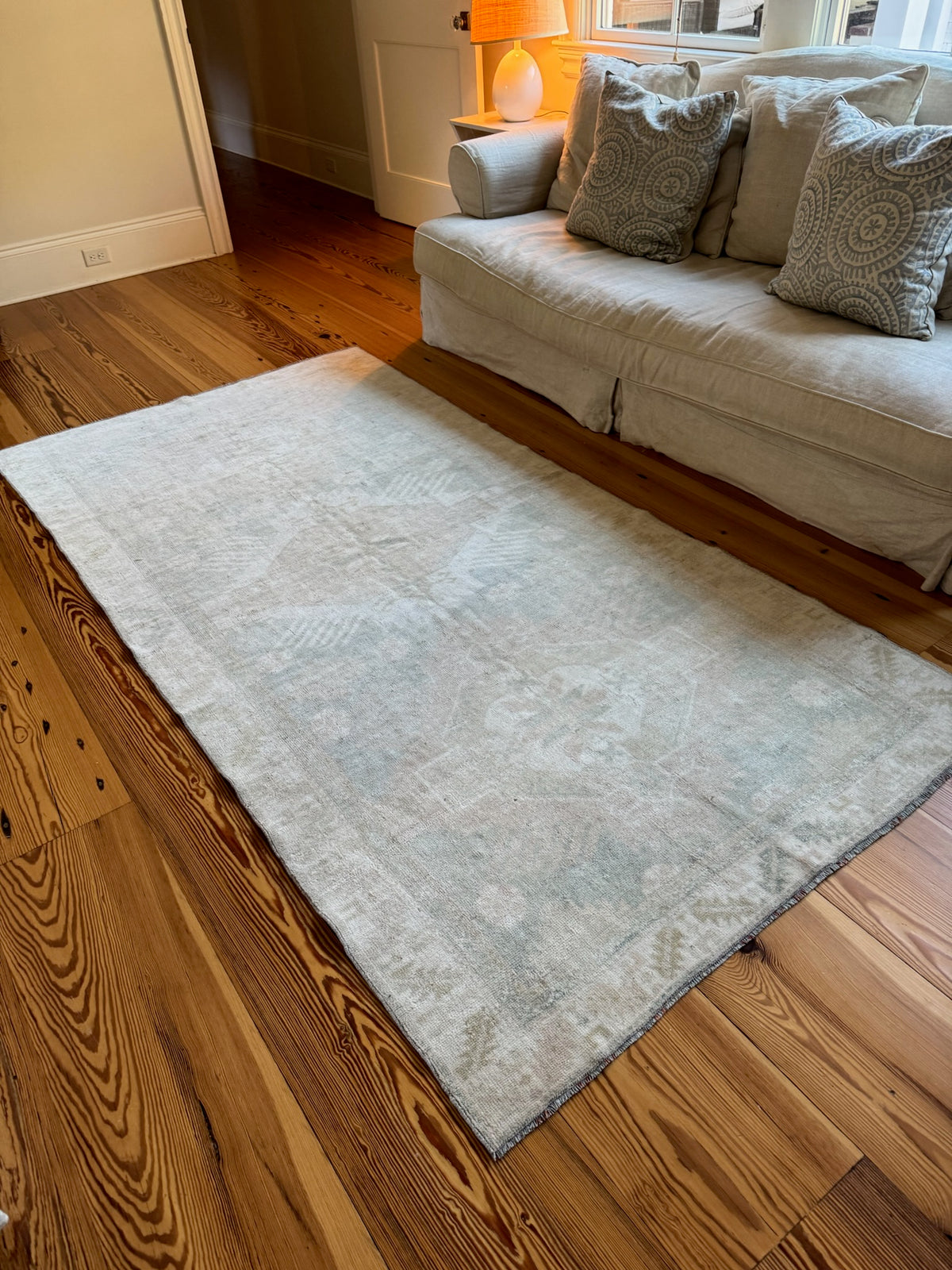 blue and tan rug in front of a sofa