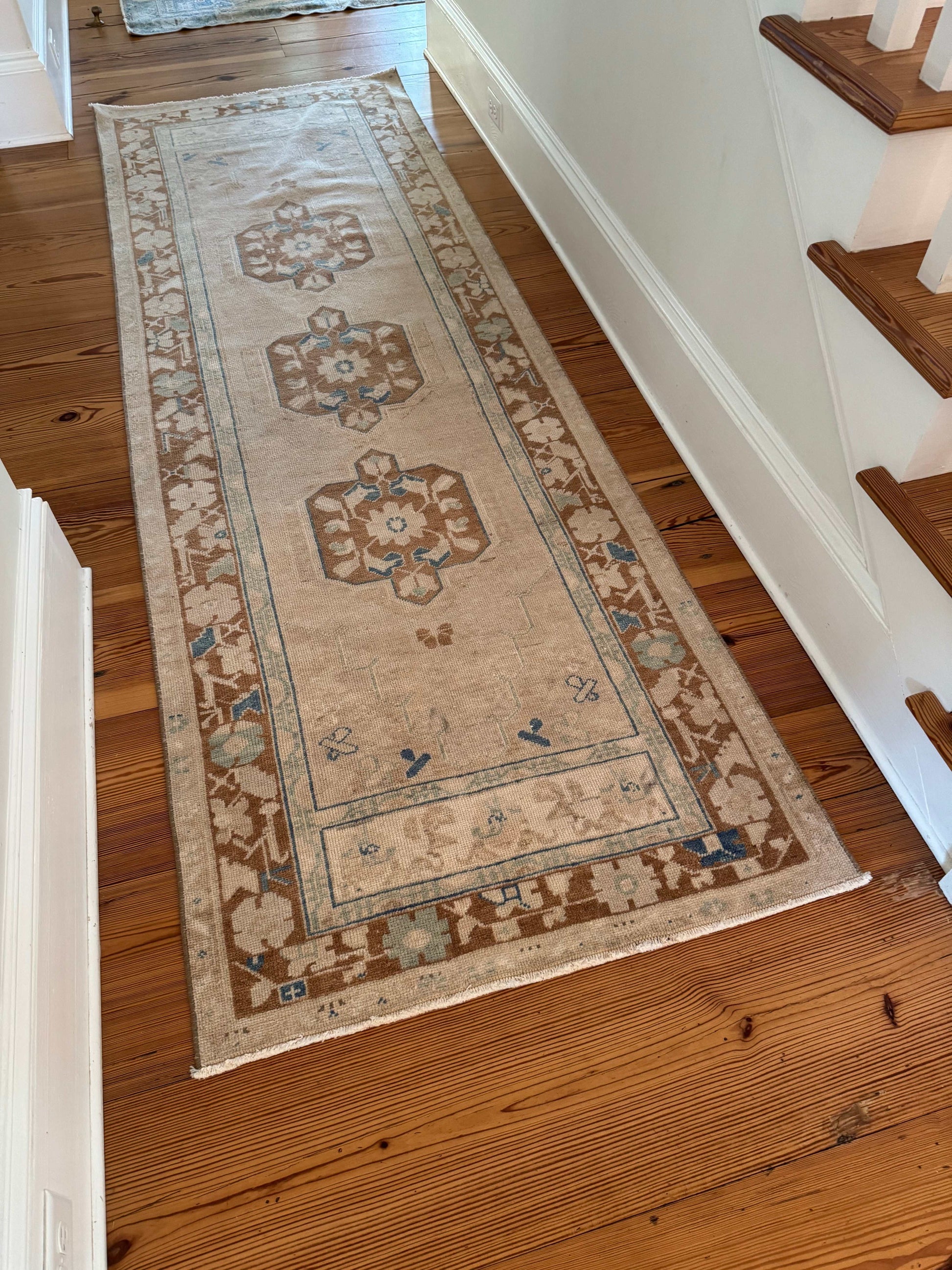 3'1" x 9'6" Turkish rug runner with beige background and brown border.